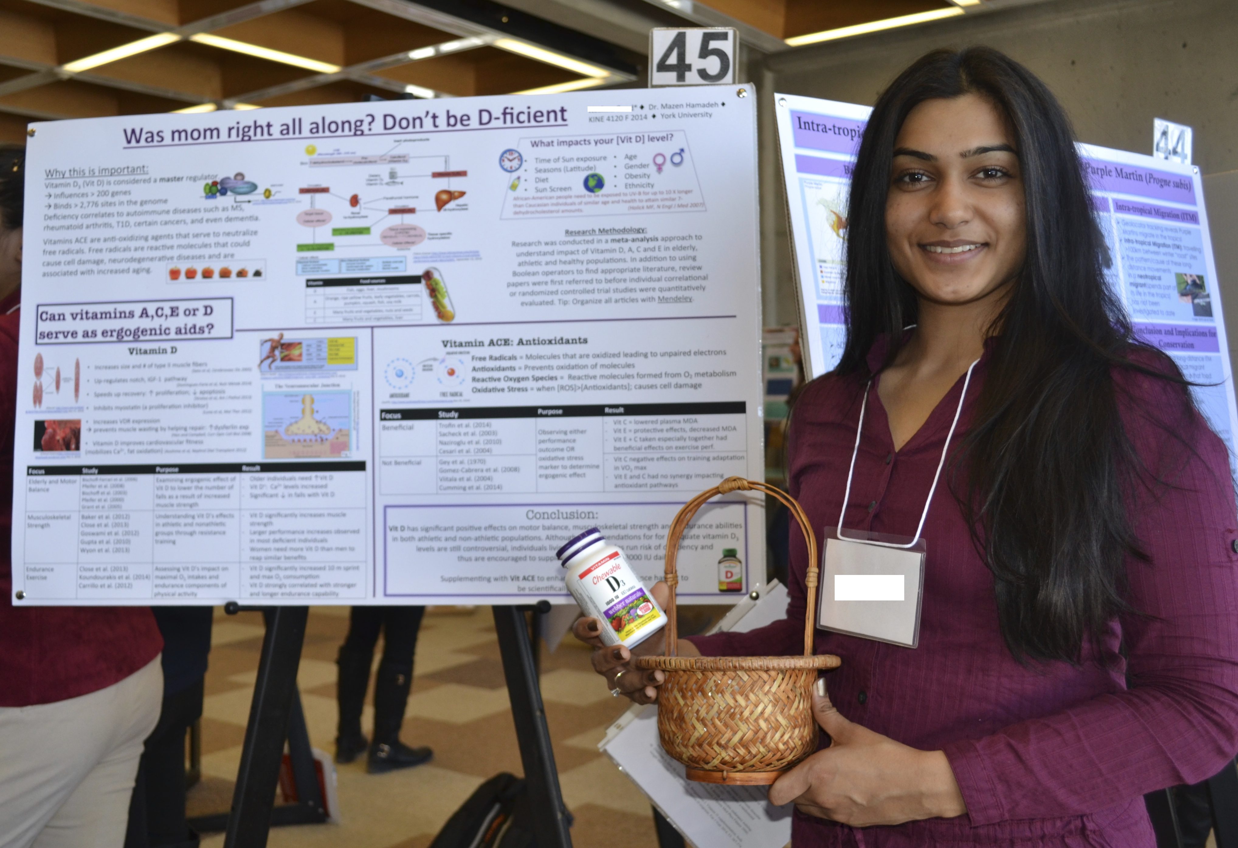 Female student standing in front of his project poster